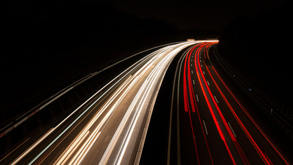 Fototapeta na wymiar Leuchtspuren der Scheinwerfer von Autos bei Nacht auf der Autobahn bei Langzeitbelichtung