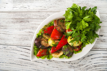 Grilled vegetables in a white plate close-up. Snack from baked vegetables with Provencal herbs to copy space.