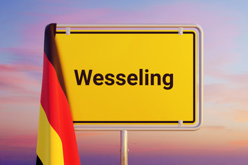 Wesseling. Gelbes Schild/Ortsschild. Flagge von Deutschland hängt darüber. Himmel mit Sonnenuntergang oder Sonnenaufgang