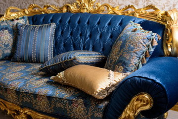 Luxury blue sofa with pillows. Baroque style.