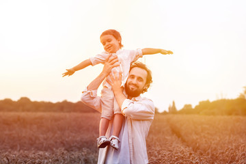 father's day. Dad and son playing together outdoors on a summer. Happy family, father, son at sunset. The concept of organic farming and healthy lifestyle,  happiness and joy © Alex Desanshe