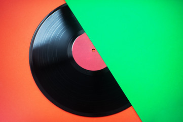 Retro style. Vinyl record on a green-red background. Top view. Minimalism. Music lover. Flat lay....