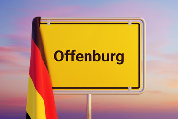 Offenburg. Gelbes Schild/Ortsschild. Flagge von Deutschland hängt darüber. Himmel mit Sonnenuntergang oder Sonnenaufgang