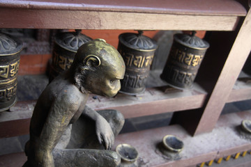 stare buddyjskie młynki modlitewne i figurka małpy