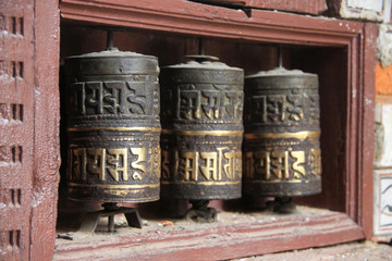 trzy stare wytarte buddyjskie młynki modlitewne
