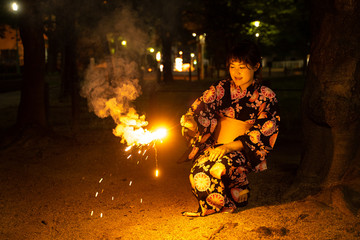 浴衣で花火をする女性