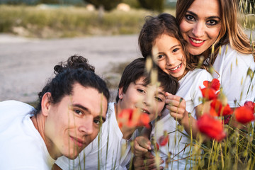 Portrait of a young family smiling and happy looking at the camera on the outside