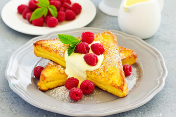 French toast with english sauce and raspberries.