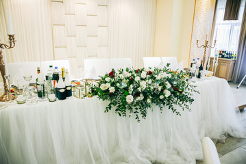 Beautiful decoration of a table at the wedding reception. White flowers. Tasty food.