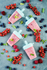 top view of delicious sweet ice lollies and fresh ripe berries on grey surface