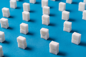 Minimalism style. White sugar cubes against blue background.