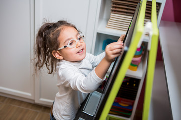 child girl with glasses for vision plays in educational classes