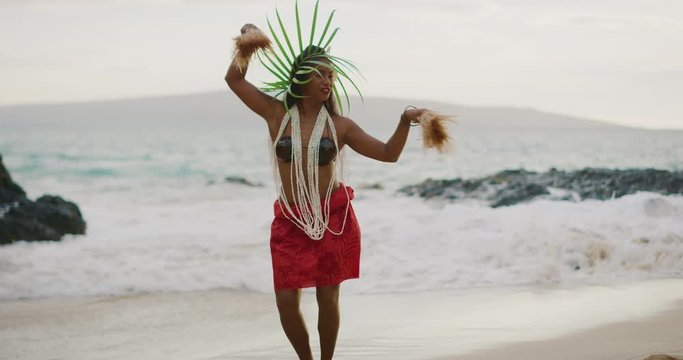 Beautiful polynesian woman performing a Tahitian hula dance on the beach in slow motion