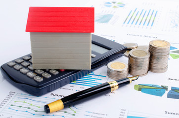 Mortgage loan concept with red house with calculator and pen money coins