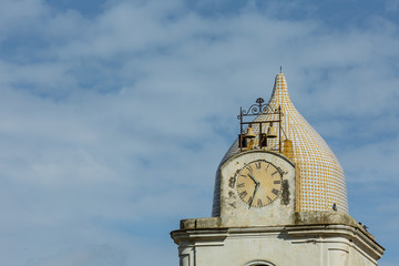 close up of a clocktower with colorful roofing tiles on the Amalfi coast, Italy