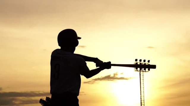 Silhouette baseball player holding a baseball bat to hit the ball drills footage slow motion