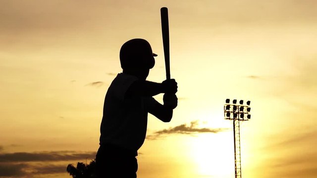 Silhouette baseball player holding a baseball bat to hit the ball drills footage slow motion