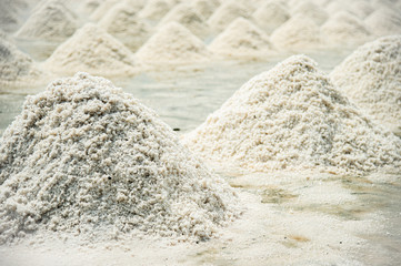 Pile up of mountain white dry salts after harvest in the salt field at Samut Songkram, Thailand.