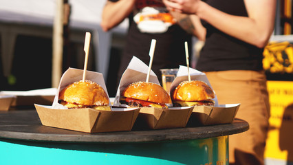 Beef burgers being served on food stall on open kitchen international food festival event of street food
