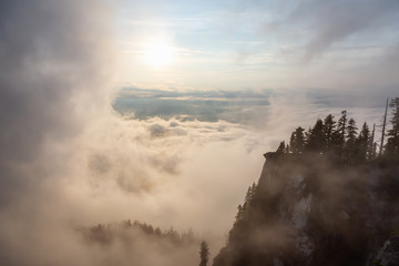 Beautiful View of Canadian Mountain Landscape covered in clouds during a vibrant summer sunset. Taken on top of St Mark's Summit, West Vancouver, British Columbia, Canada.