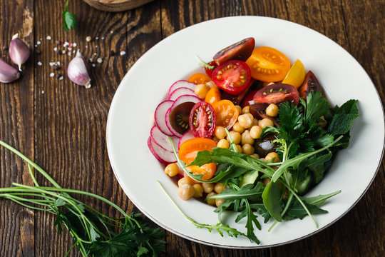 Veggie chickpeas salad with fresh vegetables and herbs, plant based meal