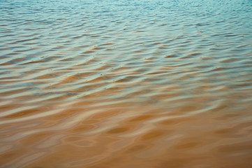 Wave of sea water prepared in the salt field to let it dry from sun and become white sea salt in the field of Samut Songkram, Thailand.