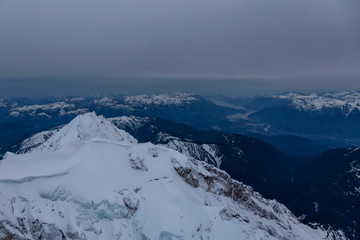 Naklejka premium Beautiful Aerial View of Canadian Mountains Landscape during a dark and cloudy evening. Taken near Squamish, North of Vancouver, British Columbia, Canada.