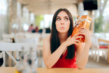 Curious Woman Checking Gift Box on a Date