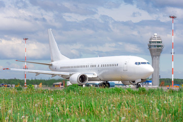Passenger aircraft in the foreground green grass on the steering track at the airport on the...