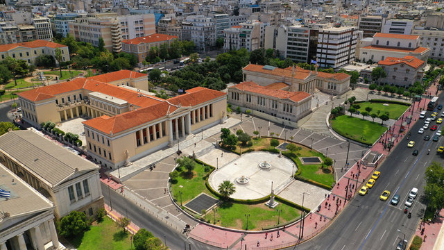 Aerial photo of iconic landmark neoclassic buildings of Academy, University and public Library in the heart of Athens historic centre with beautiful clouds, Attica, Greece