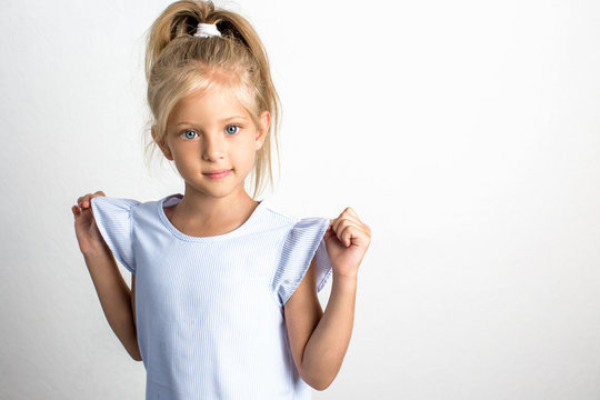 Beautiful girl with blond hair in a blue dress, a 7 year old child