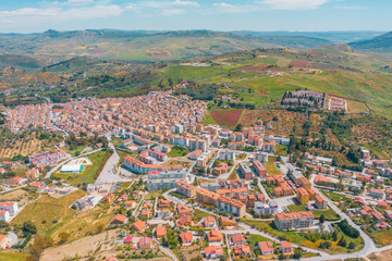 Small town in Italy among fields and hills, aerial view from a height.
