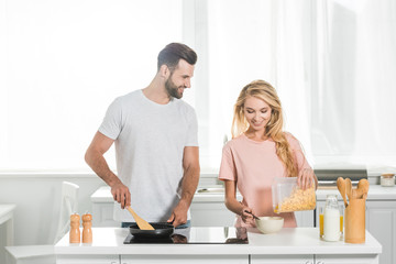 beautiful couple cooking breakfast together at kitchen