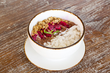 Delicious organic smoothie bowl garnished with dragon fruit, flaxseeds, sliced almonds and granola