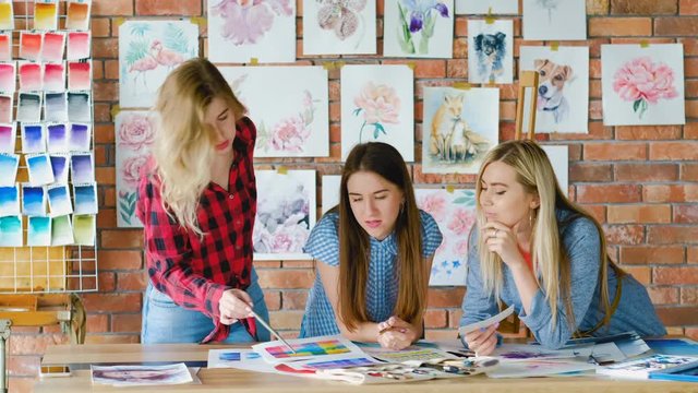 Art students in creative studion learning painting tricks and coloristics.