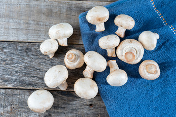 Fototapeta na wymiar Champignon mushrooms on wooden background