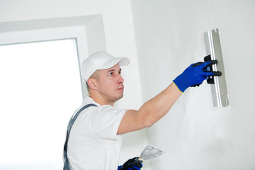 refurbishment. Worker spackling a wall with putty