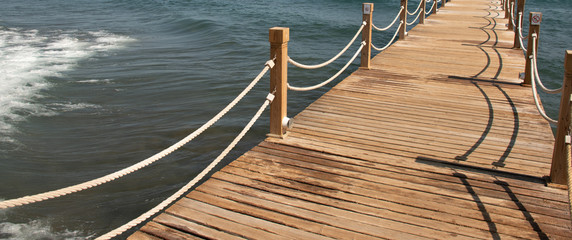 Scene at Tropical Beach Resort with wooden pier and rope