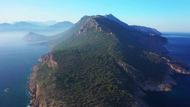 Aerial view of Torre del Pirata, an old tower on the top of a cliff, in front of the islet of Es Vedra, in the island of Ibiza, with a beautiful sunset.