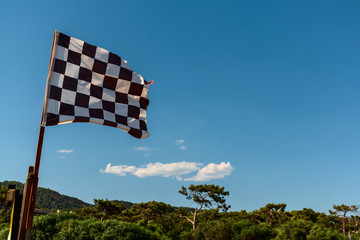 black white checkered wind flag on tropical beach