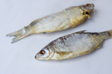 Dried fish on the table. Salty dry river fish on a white background top view