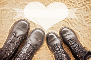 pair of shoes. A pair of boots on the sand. Pair, love, heart
