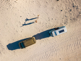 Aerial view of wanderlust people couple of women enjoying the travel with old van together - summer holiday alternative vacation and happiness for freedom - nice shadow with hands up