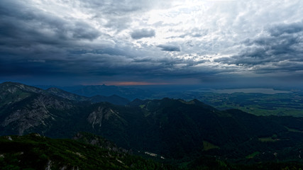 Dramatic sunset mountain sky with storm clouds and view of Chiemsee in Bavaria
