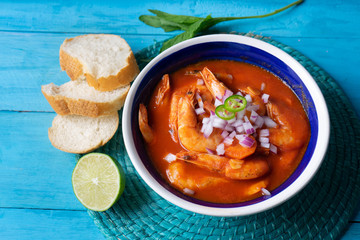 Mexican shrimp soup on blue background