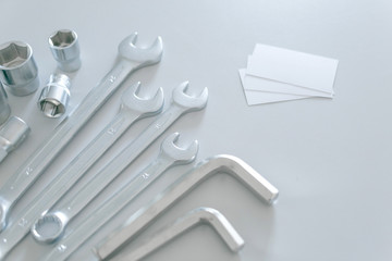 Set of a lot of different tools, such as: combination wrench, socket wrench, arm hexagons keys with blank of business card