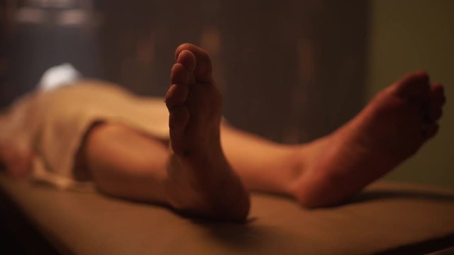 Dead male body laid out on an autopsy table comes back to life