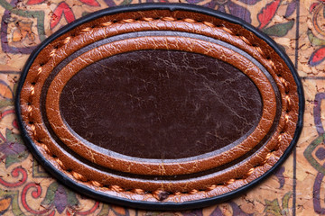 Leather background texture. Closeup of a decorative red brown leather ornament on a woman hand bag made from cork fabric. Decoration background and design element. Macro.