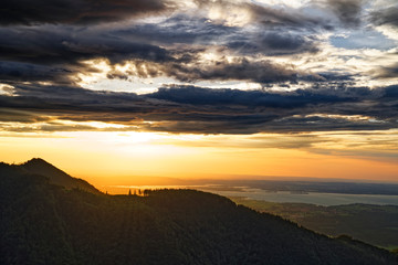 Beautiful sunset over Chiemsee lake with cloudy sky on Hochfelln mountain