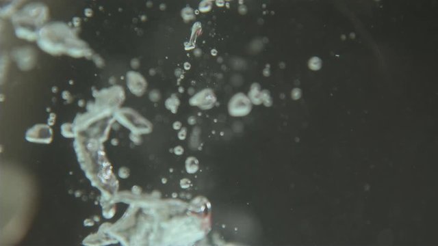 Group of quarters going through water slow motion